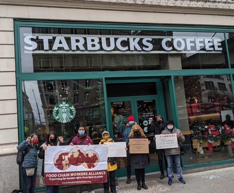 Group of eight people outside a Starbucks in New York, holding signs in support of workers at Martin’s Family Fruit Farm in Ontario. Nov 25, 2020. Photo: Justicia for Migrant Workers
