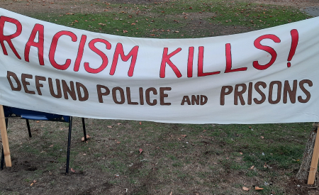 Banner saying, Racism Kills! Defund Police and Prisons