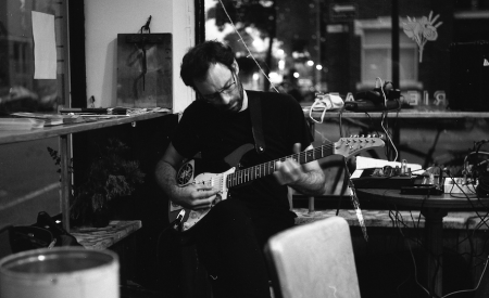 Stefan Christoff playing guitar. Photo by Philippe Teixeira St-Cyr, obtained from Stefan Christoff.