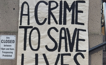 It is not a crime to save lives banner.