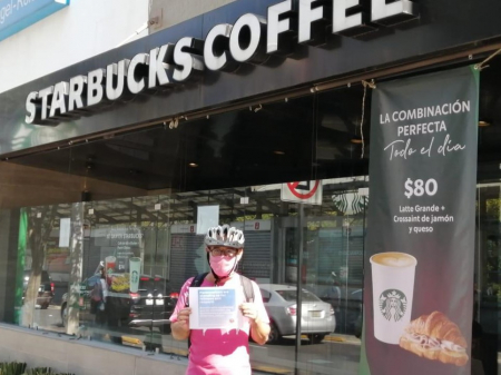 One person outside a Starbucks in Mexico, holding up a sign in support of workers at Martin’s Family Fruit Farm in Ontario. Nov 25, 2020. Photo: Justicia for Migrant Workers