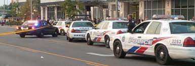 Toronto police vehicles at scene. Street blocked off.