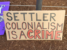 Settler Colonialism is a Crime sign.